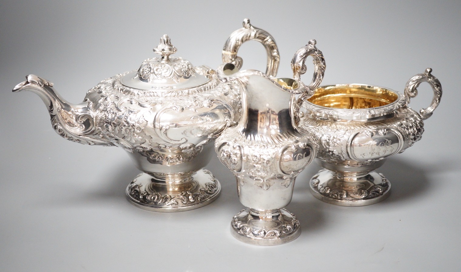 A matched Victorian embossed silver inverted pear shaped three piece tea set, teapot James Mackay, Edinburgh, 1839, cream & sugar, Charles Fox, London, 1838